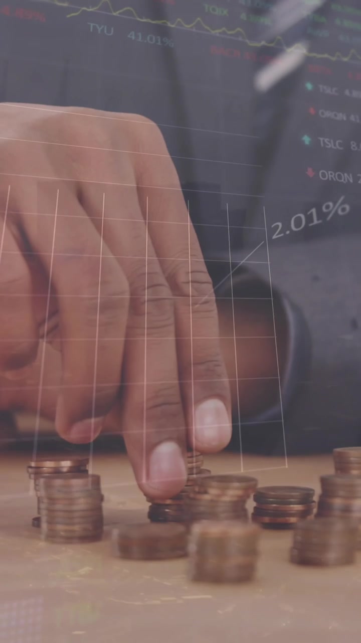 Animazione di grafici e tabelloni di trading su un uomo caucasico che guarda delle monete su un tavolo.