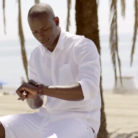 seated black male model checking his watch