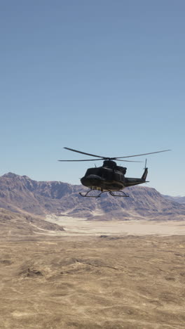 military helicopter flying over desert landscape