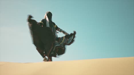 gypsy woman walking on a desert sand dune