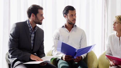 Businessman-discussing-with-his-coworker-over-document