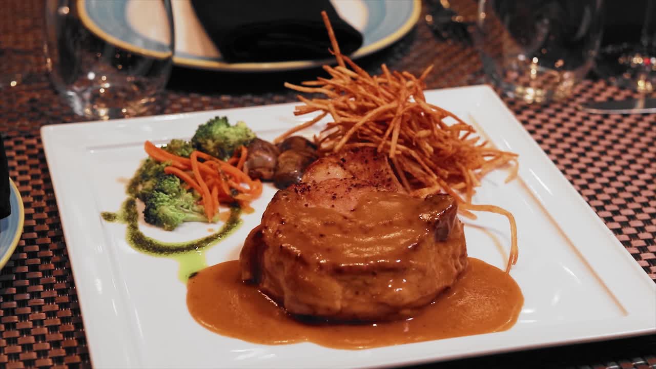 Close Dish of filet of mignon with broccoli and hash browns on white plate
