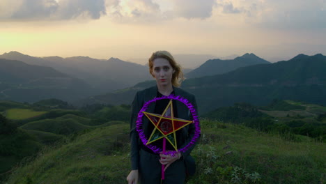 slow motion shot of a woman holding a star lantern and removing her mask on a hill