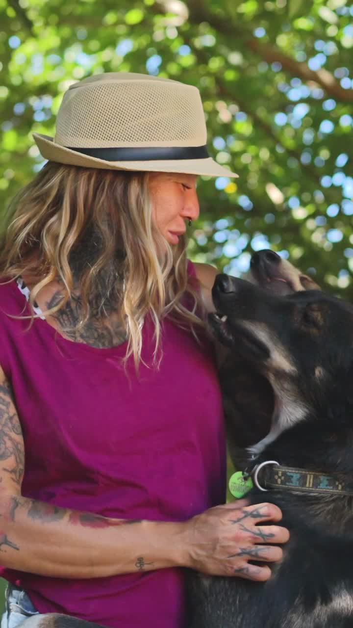 Woman in Hat Petting Her Dog Outdoors on a Sunny Day