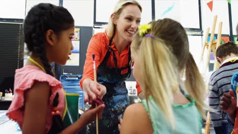 Teacher-interacting-with-students-in-drawing-class