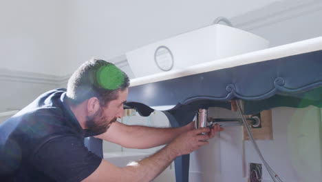 fontanero instalando una nueva trampa de residuos para lavar el lavabo en el baño