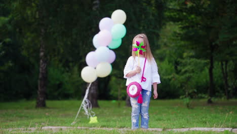 beautiful girl with wind toy. girl happily playing with wind toy in park