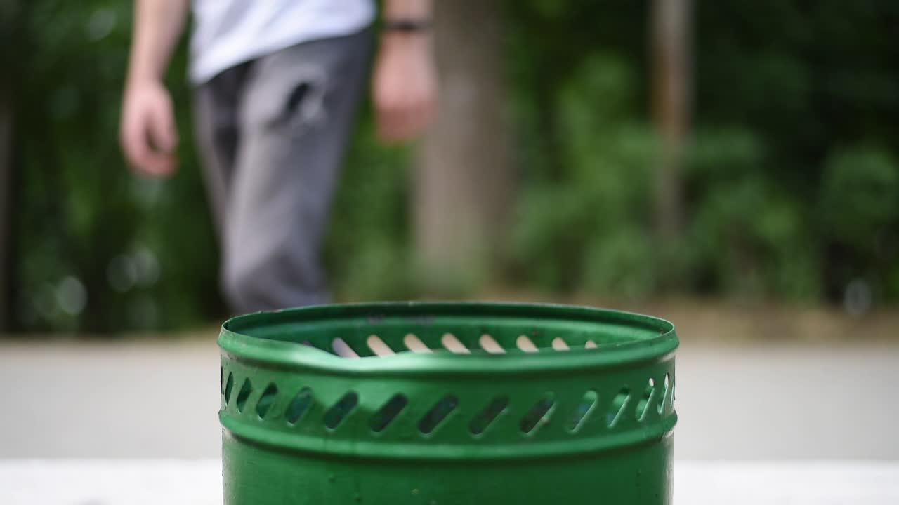 Man throwing in the bin a plastic milkshake cup