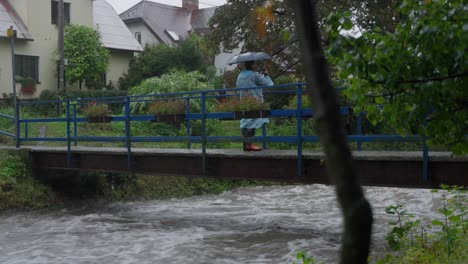 stranger standing on bridge over strong current of river and making a photos