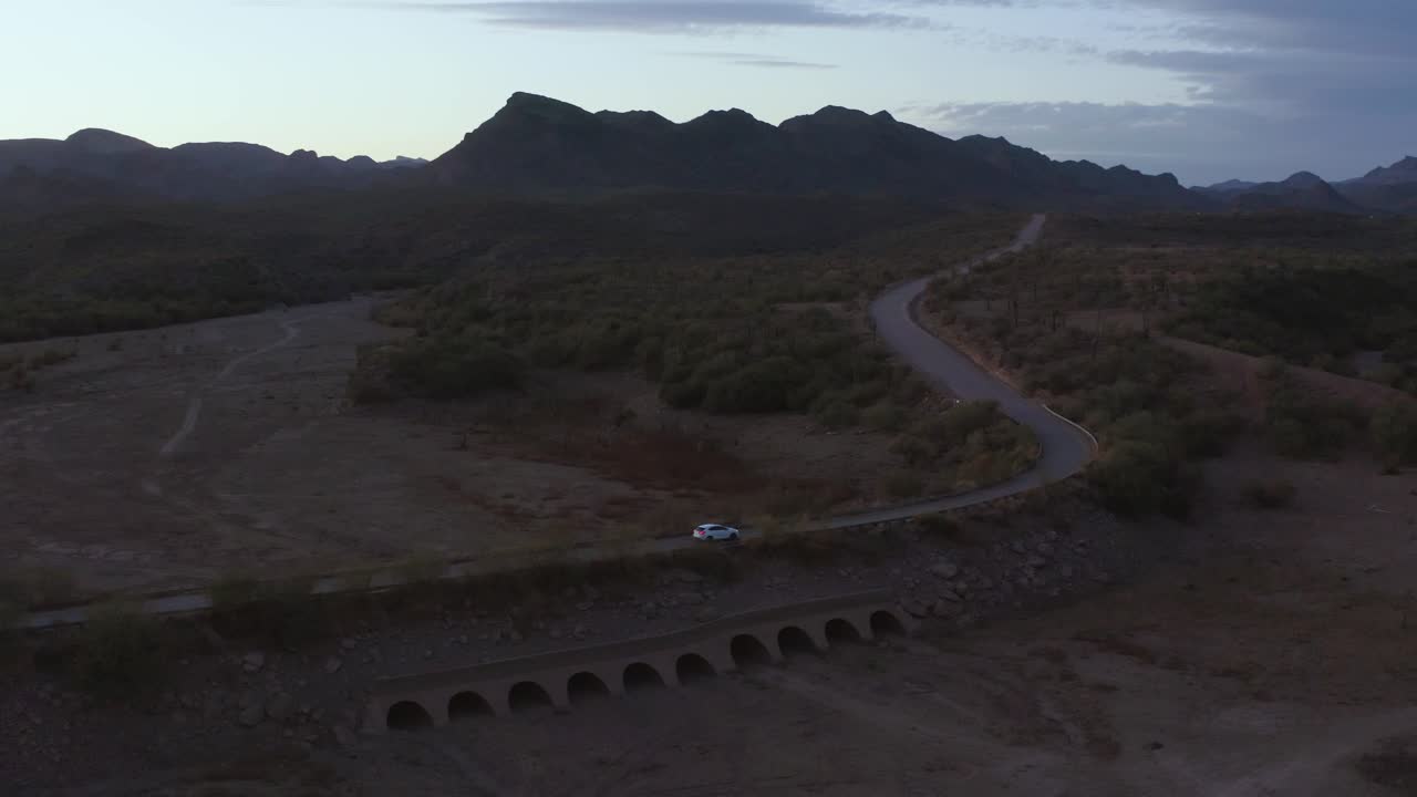SUV che guida sulla diga di un piccolo lago