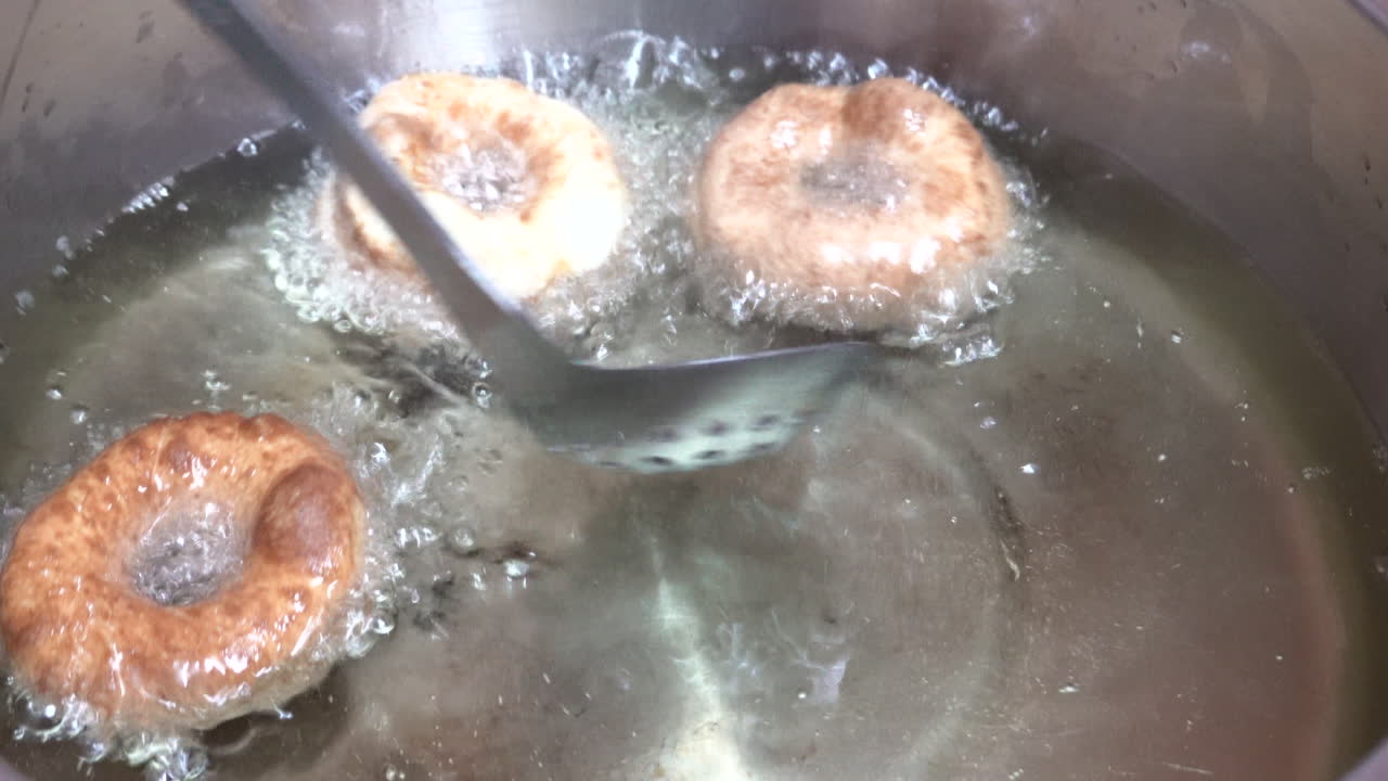 donuts fritos en aceite en un hervidor en la estufa
