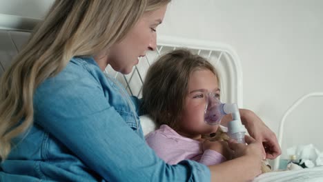 mother giving nebulizer to an ill child at home