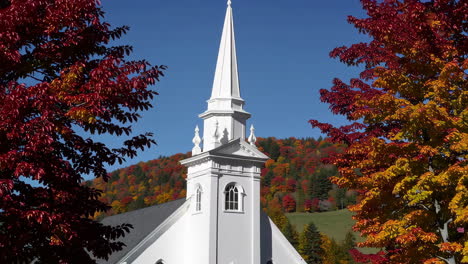 white church steeple amidst vibrant autumn foliage