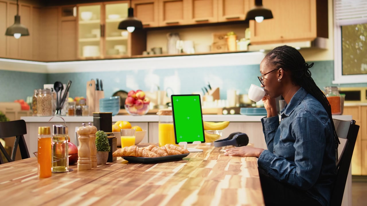 Vertical mockup green screen on tablet in kitchen at wooden table