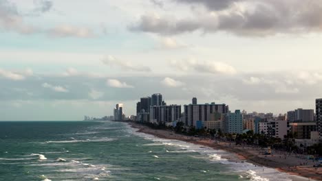 An-aerial-view-of-Hollywood-Beach,-Florida-on-a-sunny-day-from-over-the-ocean