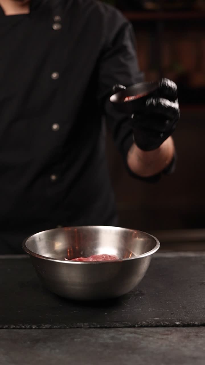 cocinero sazonando carne cruda