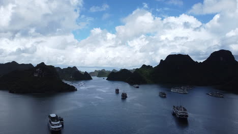 Drone-capturing-breathtaking-footage-of-cruise-ships-docked-through-the-serene-emerald-green-waters-and-mountains