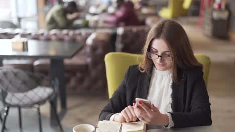 woman working on cell phone in a coffee shop