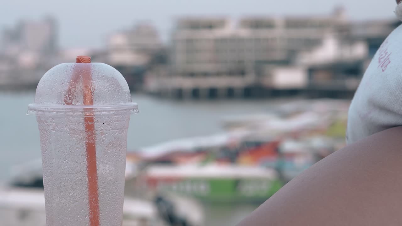 copa de plástico con paja naranja brillante en un fondo borroso
