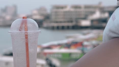 plastic cup with bright orange straw at blurred background