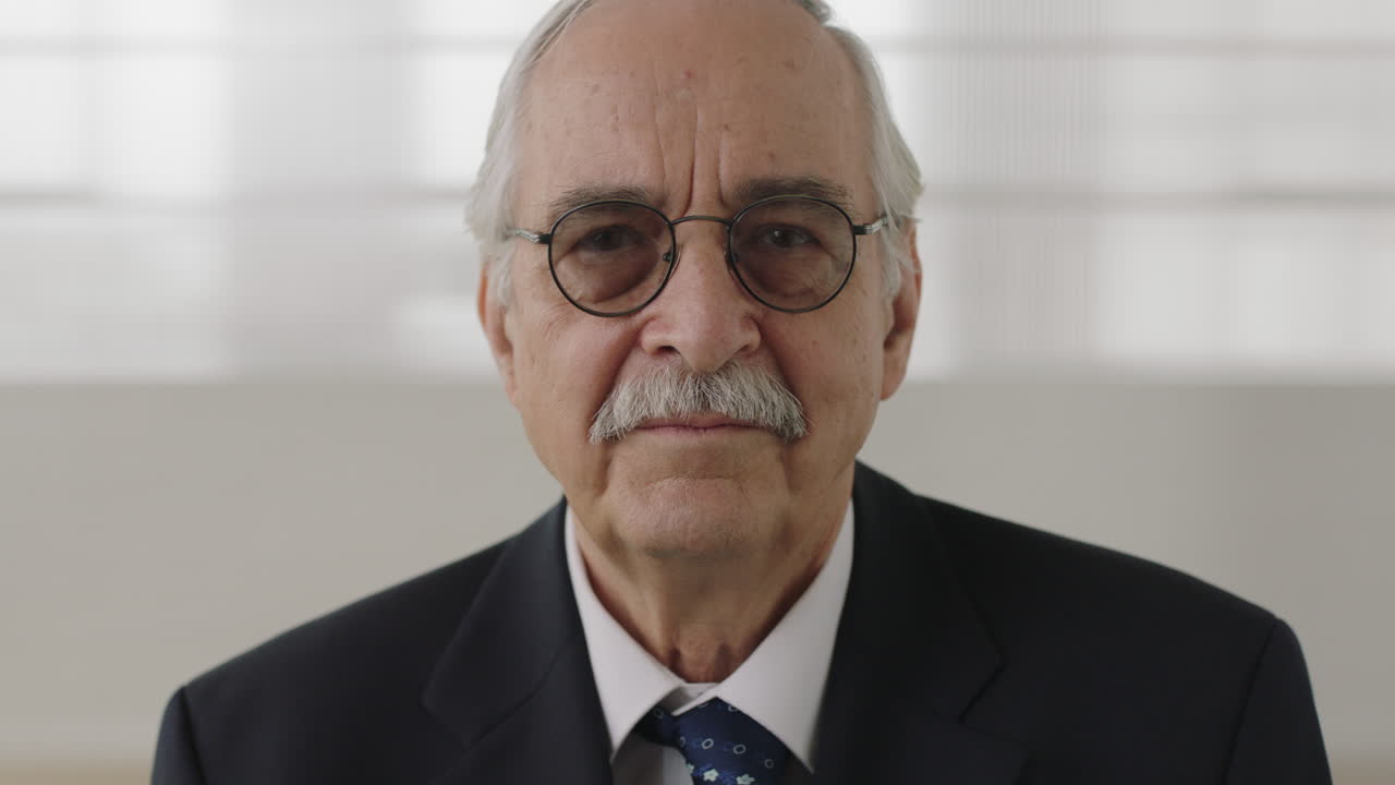 retrato en primer plano de un ejecutivo de negocios sénior que mira seriamente a la cámara un profesional de mediana edad con traje sonriendo feliz