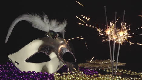 máscara de carnaval veneciano y bengalas de fiesta sobre fondo negro