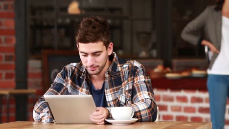 Lächelnder-Hipster-Mann,-Der-Ein-Tablet-Benutzt-Und-Kaffee-Nippt