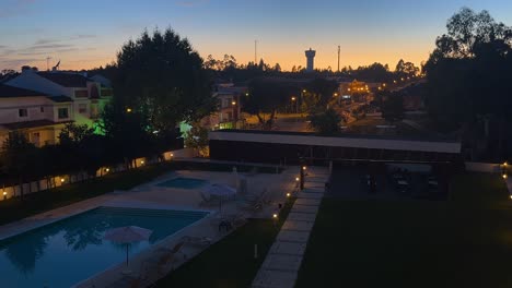 Crepúsculo-Sobre-Un-Barrio-De-Lisboa-Con-Piscina-Y-Tumbonas,-Portugal---Timelapse-Nocturno