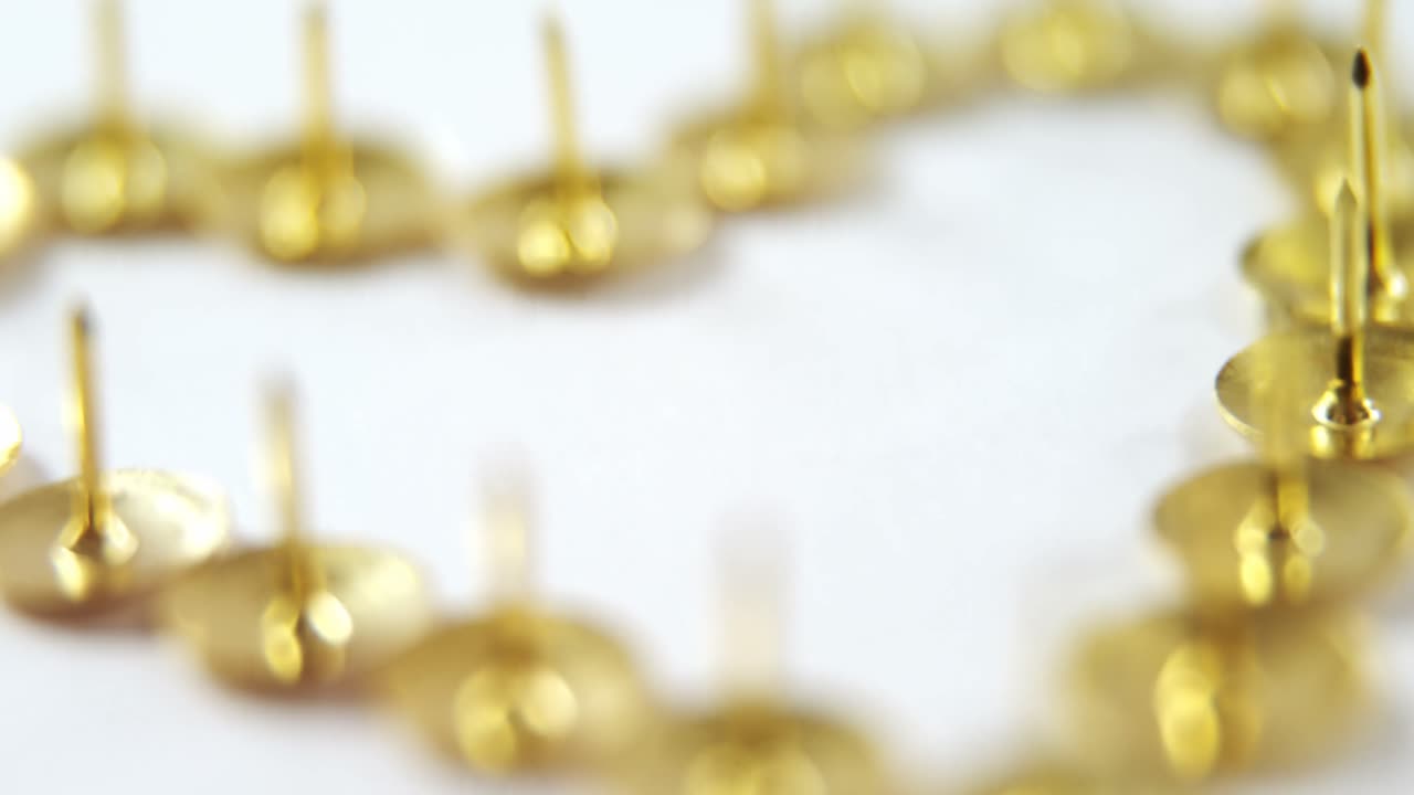 심장 모양으로 배열 된 금색 밀기 핀 4k