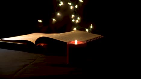 holy book with burning candle in mystical environment