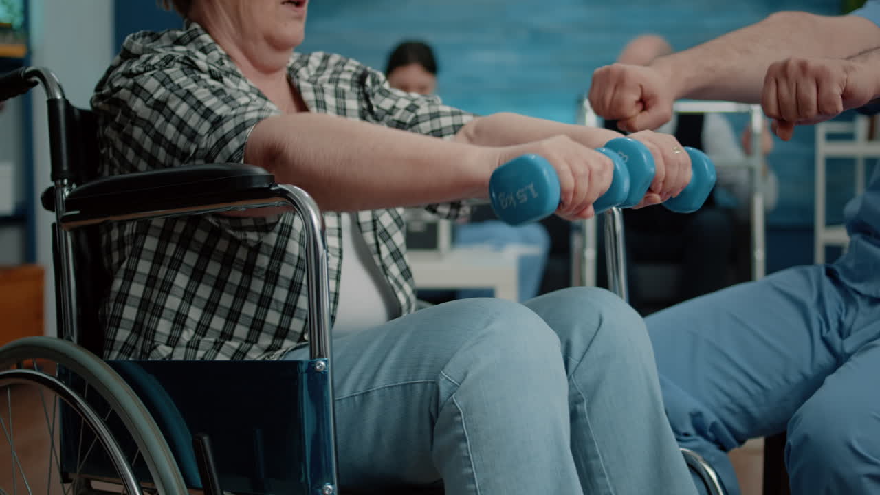 Close up of handicapped woman using dumbbells for recovery