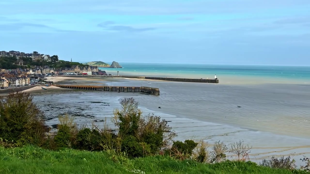 Città costiera e vista del litorale a Cancale, Francia, con edifici e acqua di mare calma