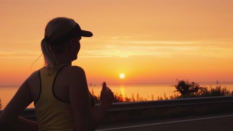 a young woman runs in a picturesque place by the sea where the sun sets over the water