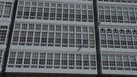 a building facade with rows of white framed windows shot from a straight-on perspective