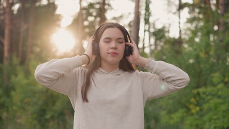 young woman listening to music in the forest