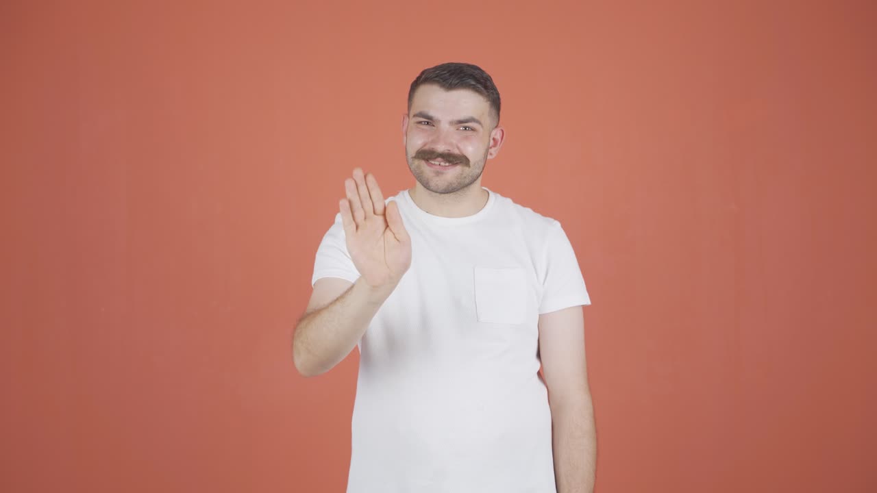 hombre feliz saludando a la cámara.