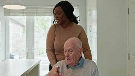 caregiver assisting elderly man in wheelchair at home