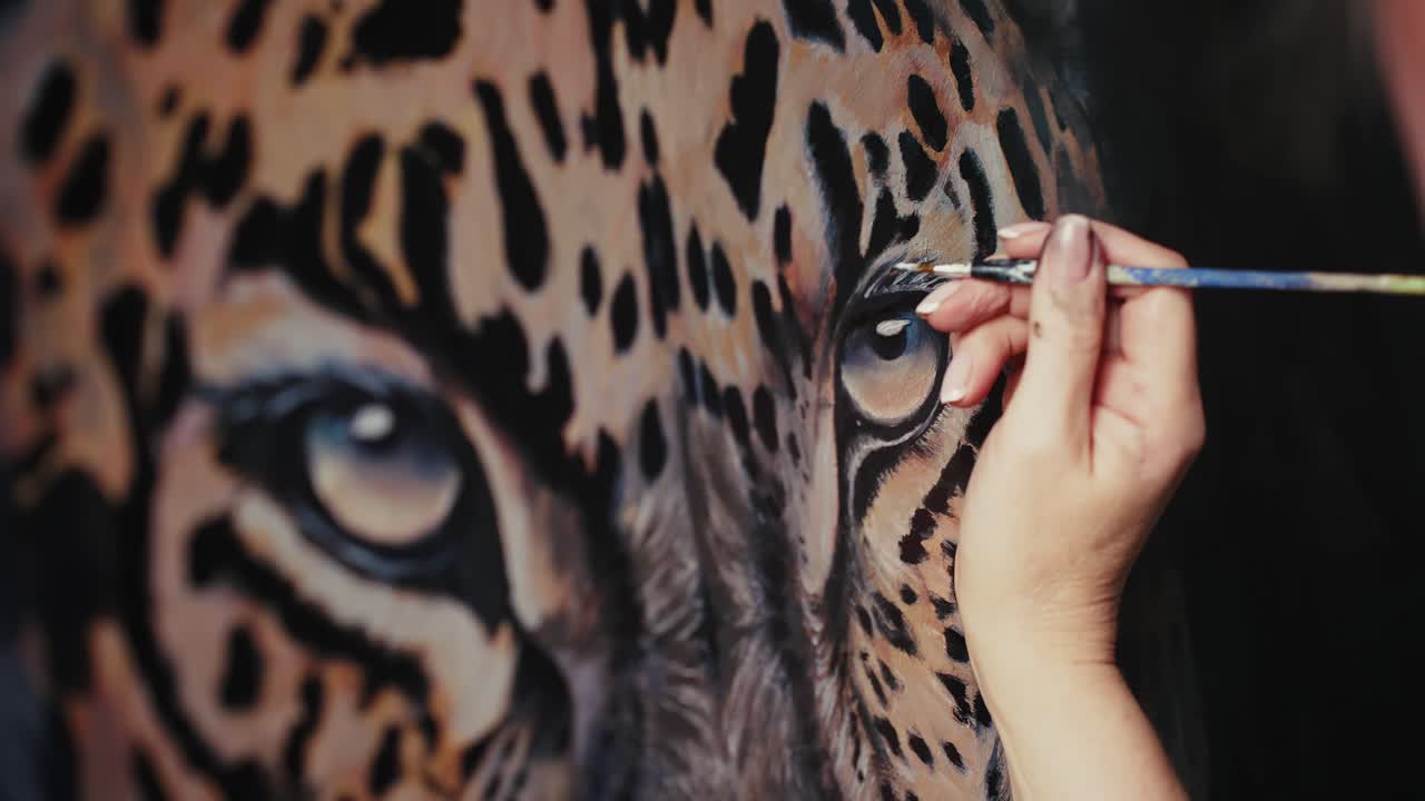 Closeup of an artist painting a jaguar eye
