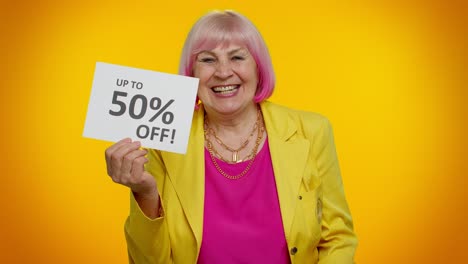 glückliche ältere frau mit einkaufstaschen und einem schild, auf dem "bis zu 50% rabatt" steht