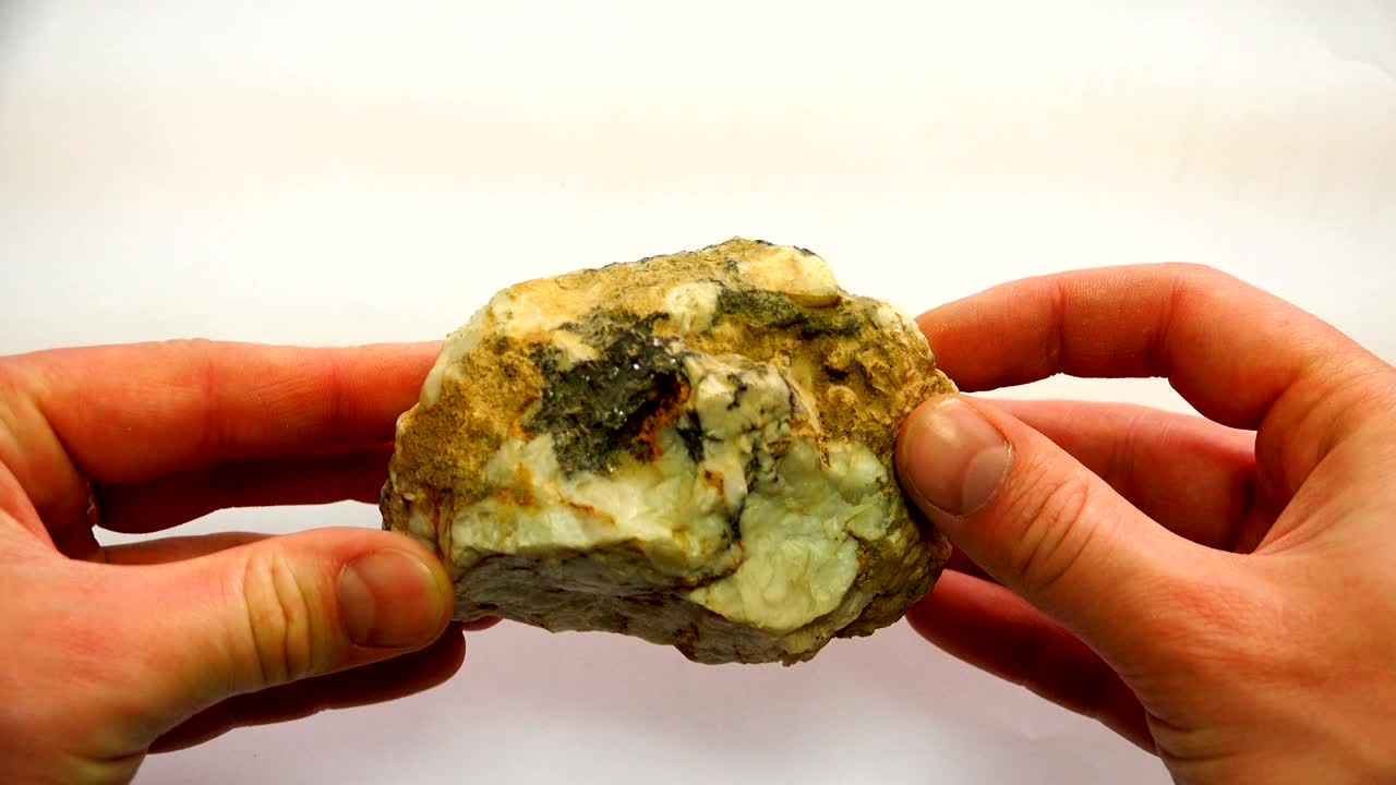 전문의의 손에 휘어지는 정맥이 있는 광물 돌