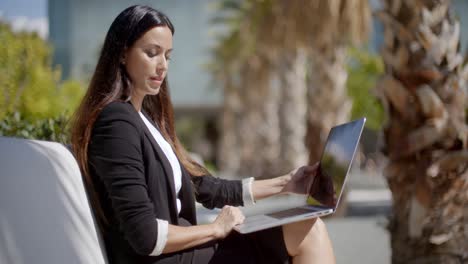 Businesswoman-sitting-working-in-an-urban-park