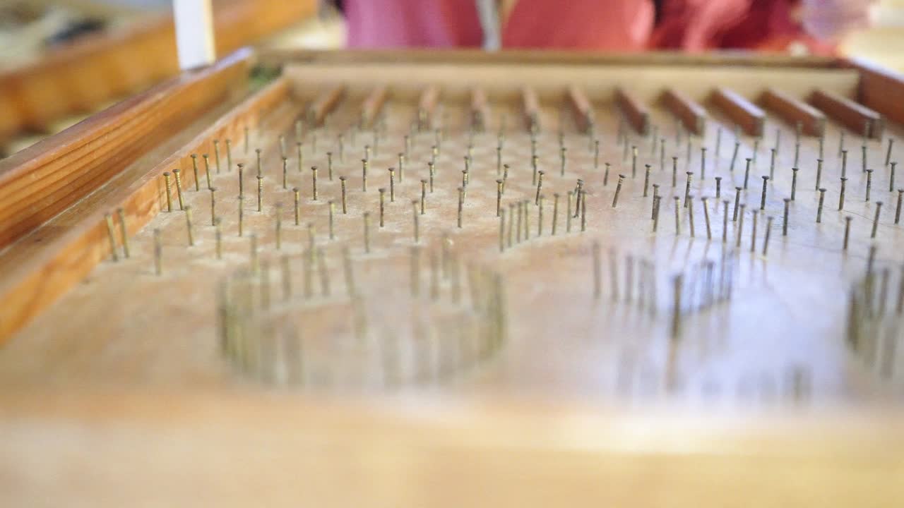 cerca de la mesa de pinball hecha de madera. las cuentas de vidrio rodan hacia abajo en la mesa de flipper. un juego jugado por un niño. el tema está a la izquierda.