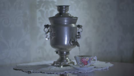 pouring hot water from a soviet vintage samovar electric metal tea kettle into a gorgeous cup-2