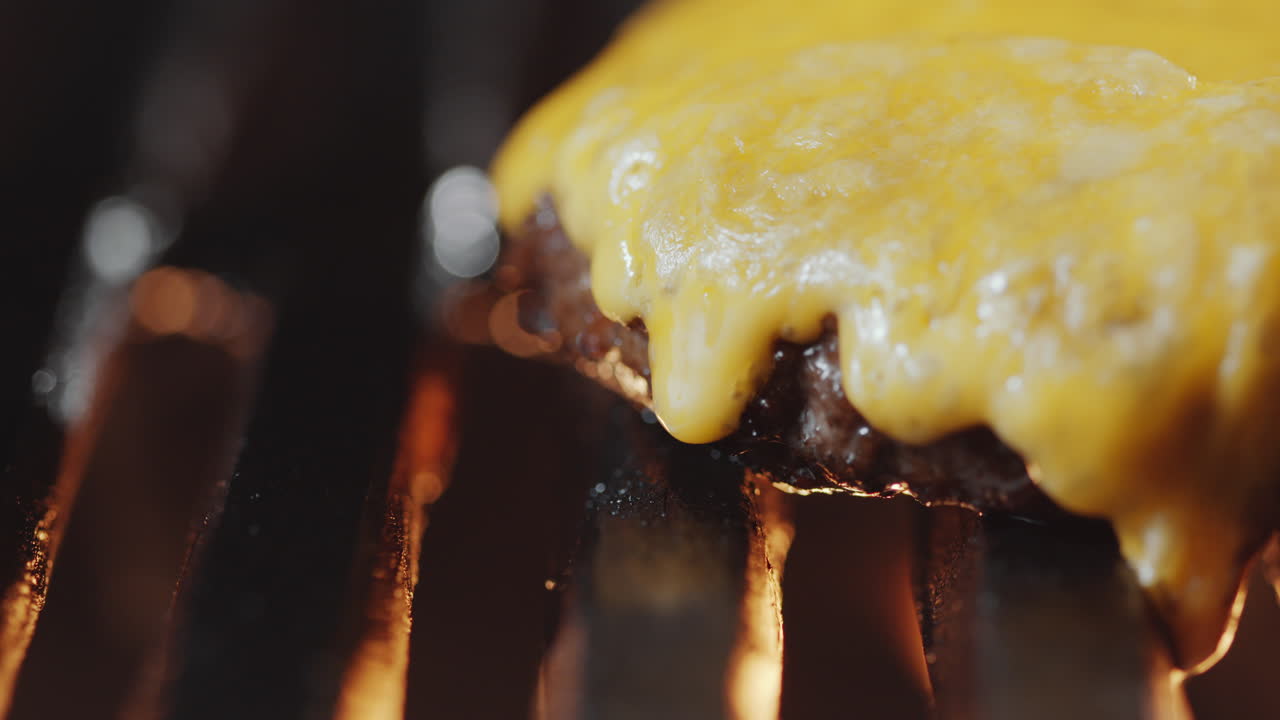 carne de hamburguesa con queso derretido en la parrilla ardiente