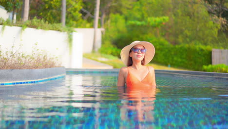 Elegante-Mujer-De-Moda-Sentada-Dentro-Del-Agua-De-La-Piscina-En-Un-Hotel-Exótico-En-Turquía-Cámara-Lenta-De-Mano