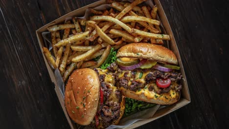 deliciosas hamburguesas con queso y papas fritas en la caja de comida para llevar
