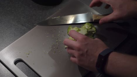 High-angle-view:-Home-chef-cuts-fresh-broccoli-crown-into-florets