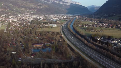 Flying-backwards-revealing-the-town-of-Sallanches-and-the-Arve-valley,-as-well-as-the-Aravis-Mountain-range