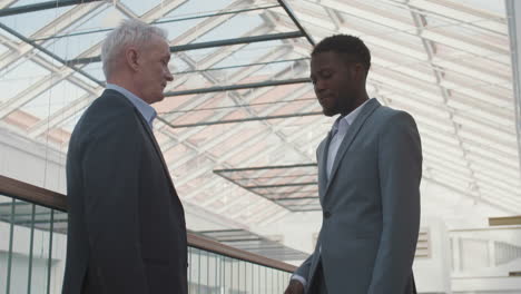 diverse male business partners shaking hands