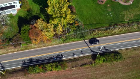 una vista aérea de una carretera de dos carriles con casas y un campo verde